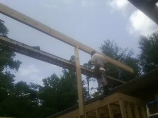 Carpenter setting a ridge beam over a new addition frame — Ice Dam Removal by Roofing Brothers in Bannock